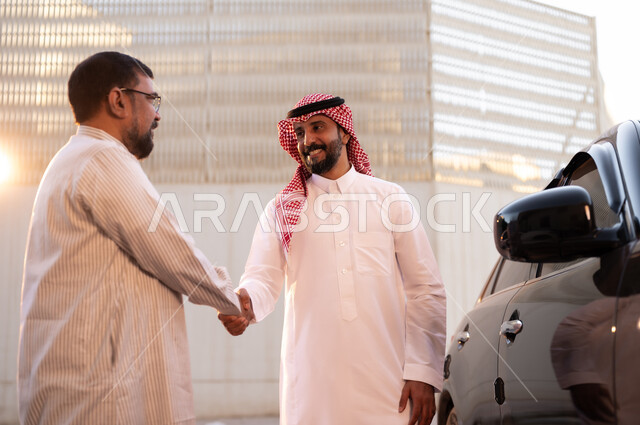 وظائف ومهن سعودية، استقدام العمالة من الخارج، رجل عربي سعودي خليجي يرتدي الشماغ والثوب التقليدي يقوم بمصافحة  السائق الباكستاني يتحادثان بإيماءات السرور، مفهوم القيادة والتوصيل، نهاية دوام العمل