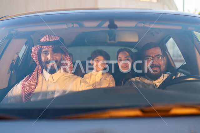 Saudi professions and jobs, recruiting workers from abroad, a smiling Pakistani driver wearing glasses sitting in the car transporting an Arab Gulf family, looking at the camera with happy gestures, the concept of driving and delivering