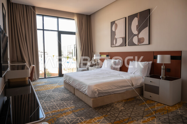 فنون الهندسة المعمارية والديكور في الفنادق والمنتجعات الفاخرة، سرير ووسائد مريحة، أثاث منزلي راقي وأنيق، لوحات فنية معلقة، غرف بتصاميم داخلية عصرية، شقق وفلل سكنية بديكورات متطورة، تصميم داخلي لغرفة نوم بأسلوب حديث