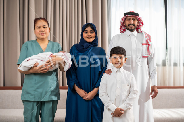 Exchanging affection and love between individuals, taking a memorial photo of the family, women’s professions and jobs, a Filipina worker carrying an infant with gestures of love and tenderness, bringing in licensed and qualified domestic workers from abroad, good treatment of foreign maids, spending enjoyable times with the family, a happy family atmosphere.