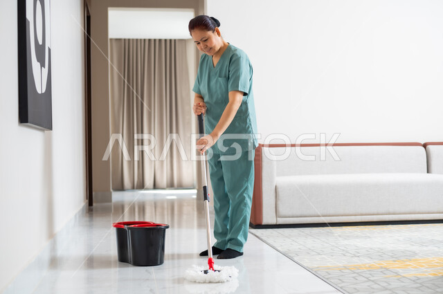 المهام والأعمال المنزلية الروتينية، عاملة نظافة ترتدي اليونيفورم الخاص بالعمل تقوم  بمسك وتنظيف البيت، استقدام العمالة الاجنبية المنزليه المدربة، مهن ووظائف نسائية، جودة الخدمات في السعودية