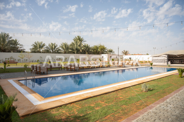 تصاميم عصرية للمسابح المتميزة في الحديقة الخارجية، الأشجار والنباتات الخضراء المحيطة بالشقق والفلل السكنية السياحية، تصميمات وديكورات فخمة، الفن الهندسي المعماري على الطراز الحديث، النمو والتقدم العمراني في المملكة العربية السعودية