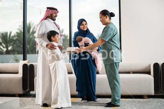 استقدام العمالة الخارجية المرخصة والمؤهلة, إدخال السرور لقلب الخادمة, قضاء أوقات عائلية ممتعه, الشكر والتقدير والعرفان, فتى عربي خليجي سعودي يرتدي الثوب التقليدي يقوم بتقديم الكيك للعاملة الأجنبية, الاحتفال بعيد الميلاد بإيماءات السعادة والفرح