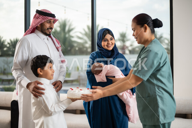 إدخال السرور لقلب الخادمة, قضاء أوقات عائلية ممتعه, الشكر والتقدير والعرفان, استقدام العمالة الخارجية المرخصة والمؤهلة, فتى عربي خليجي سعودي يرتدي الثوب التقليدي يقوم بتقديم الكيك للعاملة الأجنبية, الاحتفال بعيد الميلاد بإيماءات السعادة والفرح