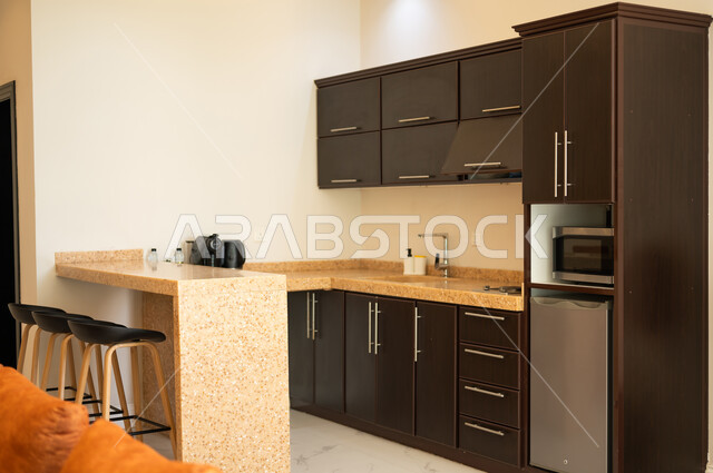 الديكور الداخلي الراقي والبسيط، التصاميم العصرية الحديثة للمطابخ في الشقق والفلل السكنية بالمملكة العربية السعودية، مطبخ كلاسيكي بخزائن خشبية غامقة، الفن الهندسي والديكورات الفاخرة