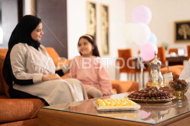 Family visits and the exchange of congratulations and greetings between family members with gestures of joy and happiness, the Eid atmosphere among the family, a portrait of an Arab Gulf-Omani family celebrating the Happy Eid, the provision of sweets and popular hospitality, holiday rituals and Islamic occasions in the Sultanate of Oman