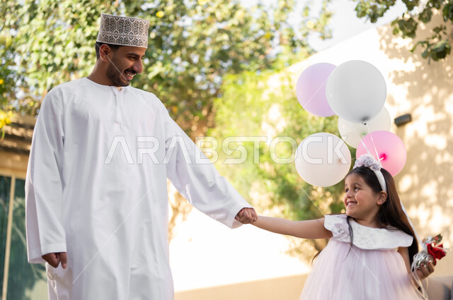 Taking a walk and spending happy times in private restrooms, a portrait of an Arab Gulf Omani family walking around inside a residential compound, playing and spending fun times and happy events inside the residential neighborhood, family housing in the Sultanate of Oman, luxury villas and apartments.