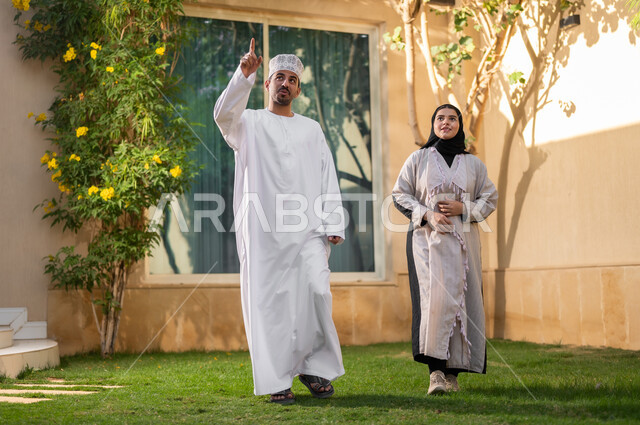 Taking a walk and spending happy times in private restrooms, a portrait of an Arab Gulf Omani family walking around inside a residential compound, playing and spending fun times and happy events inside the residential neighborhood, family housing in the Sultanate of Oman, luxury villas and apartments.