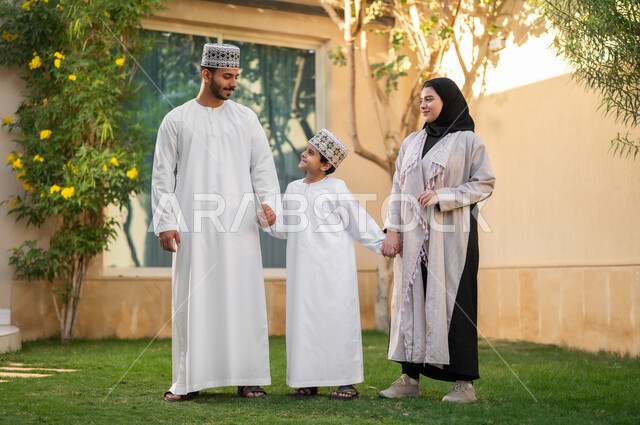 Taking a walk and spending happy times in private restrooms, a portrait of an Arab Gulf Omani family walking around inside a residential compound, playing and spending fun times and happy events inside the residential neighborhood, family housing in the Sultanate of Oman, luxury villas and apartments.