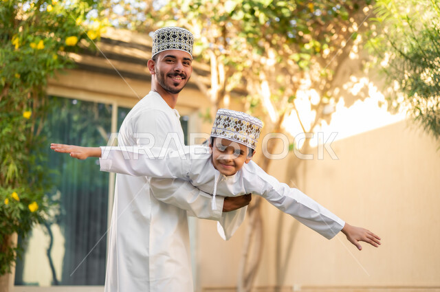 Taking a walk and spending happy times in private restrooms, a portrait of an Arab Gulf Omani family walking around inside a residential compound, playing and spending fun times and happy events inside the residential neighborhood, family housing in the Sultanate of Oman, luxury villas and apartments.