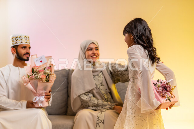 استقبال العيد بالهدايا والأزهار، تقدير الوالدين والبر بهم، المودة والمحبة بين أفراد الأسرة، تقوية الروابط الزوجية، بورتريه لرجل عربي خليجي عماني يرتدي الدشداشة والكمه يحمل باقة من الورود الملونة، عائلة عمانية تحتفل بسعادة، بخلفية ملونة