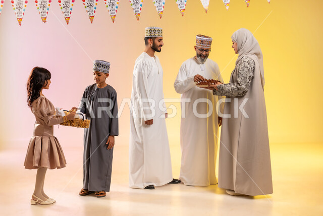 طقوس الاحتفالات والمناسبات السعيدة في سلطنة عمان، تقديم الضيافة وتوزيع الحلويات الشعبية في العيد، بورتريه لعائلة عربية خليجية عمانية تظهر مشاعر الفرح والسعادة بالاحتفال بالأعياد، الوقوف وارتداء الأزياء العمانية التقليدية، تعليق حبال الزينة المبهجة، خلفية ملونة