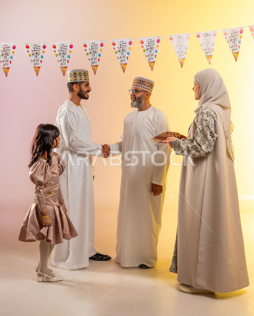حبال الزينة وطقوس الاحتفالات، التهنئة والمصافحة والتحية بين أفراد الأسرة, أجواء البهجة والسعادة في العيد, بورتريه لعائلة عربية خليجية عمانية تحتفل بالأعياد الاسلامية, تقديم الحلويات التقليدية والمأكولات الشهية, إظهار مشاعر المودة والمحبة العائلية, خلفية ملونة
