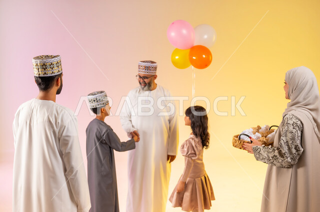 Showing feelings of family affection and love, an atmosphere of joy and happiness on Eid, a portrait of an Arab Gulf Omani family celebrating Islamic holidays, greetings and handshakes between family members and congratulations, colorful balloons and decorations, offering traditional sweets and delicious foods, a colorful background.
