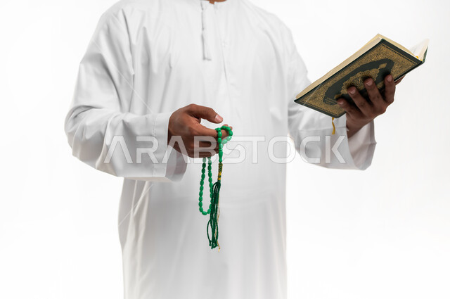 الشعور بالخشوع والطمأنينة، بورتريه مقرب لشاب عربي خليجي عماني يرتدي الدشداشة والكمه يحمل بيده المصحف الشريف والسبحة، تدبر آيات القران الكريم، الإكثار من ذكر الله تعالى من خلال الاستغفار والدعاء، الاجتهاد في العبادة، التقرب الى الله في شهر رمضان، خلفية بيضاء