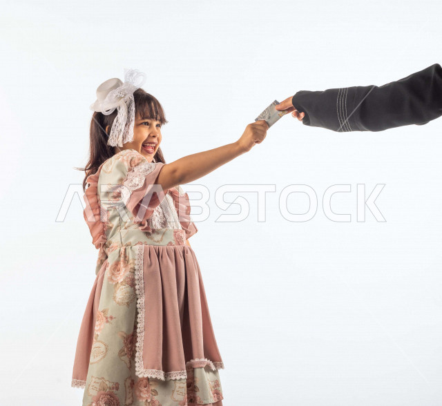 خلفية بيضاء لفتاه صغيرة سعودية خليجية مبتسمة وجميلة ، تأخذ العيدية بيدها بإيماءات وجه ويدين مختلفة , بورتريه لطفلة سعودية خليجية سعيدة ترتدي لباس العيد الانيق , الاحتفال بعيد الفطر السعيد ،عيد الفطر المبارك, تقديم العيدية للأطفال في عيد الفطر المبارك