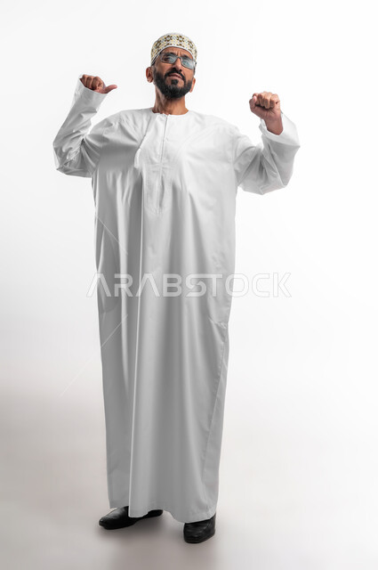 حركة يدين تدل على تمطيط الجسم، بورتريه لرجل عربي عماني شايب يرتدي الدشداشة والكمه تظهر عليه علامات الاستيقاظ من النوم، محاولة التيقظ و التخلص من النعاس، خلفية بيضاء