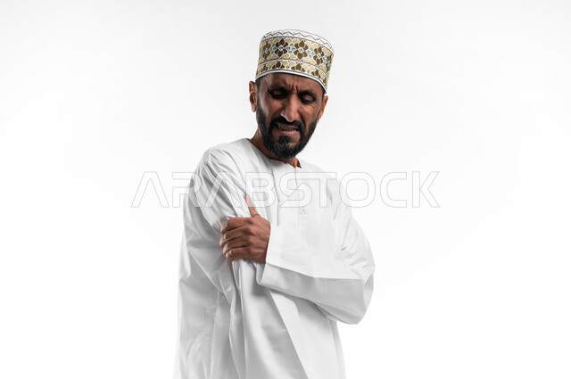 Tooth decay and gingivitis, requesting treatment, close-up portrait of an elderly Arab Gulf Omani man wearing a dishdasha and a cuff, placing a hand on his cheek, blinking red with gestures of feeling toothache, need as described by the doctor, black background.