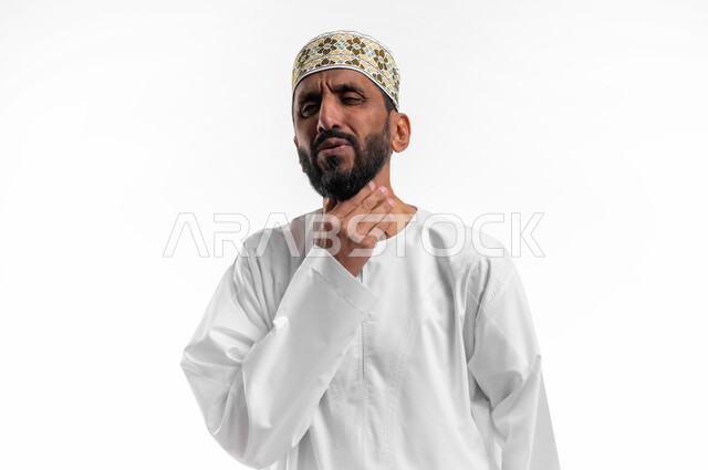 The feeling of sore throat, the need for treatment and medicine, the concept of caring for health, having a cold and sore throat, a portrait of an old Arab, Gulf, Omani man wearing a sleeve and a dishdasha, putting his hands on his throat and feeling suffocated, white background.