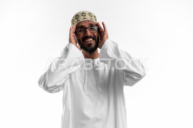 ايماءات الطرب والغناء، الترنم على ألحان الأغاني، بورتريه لرجل عماني شايب يرتدي الدشداشة والكمه تظهر عليه علامات الفرح والسرور، التبسم والدخول في جو الموسيقى، خلفية بيضاء