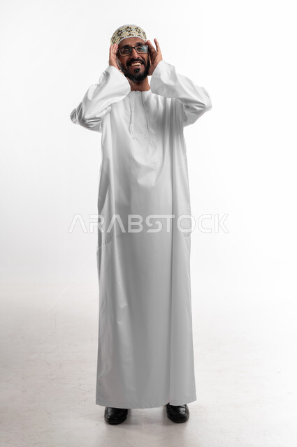 ايماءات الطرب والغناء، الترنم على ألحان الأغاني، بورتريه لرجل عماني شايب يرتدي الدشداشة والكمه تظهر عليه علامات الفرح والسرور، التبسم والدخول في جو الموسيقى، خلفية بيضاء
