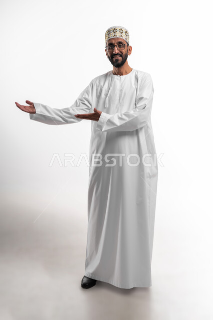إشارات يد تدل على الترحيب، حسن الاستقبال والضيافة، بورتريه لرجل عماني شايب يرتدي الدشداشة والكمه تظهر عليه علامات الفرح والسرور، ابتسامة لطيفة تدل على المحبة، خلفية بيضاء