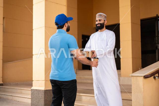 عملية شراء الكترونية، خدمات التوصيل السريع للمأكولات و المشروبات الساخنة, شاب عربي خليجي عماني يرتدي الدشداشة و الكمة يقوم باستلام المشتريات, مفهوم التسوق الالكتروني و الطلبات أونلاين