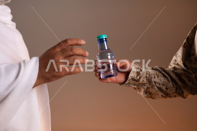 Helping pilgrims and Umrah pilgrims coming to Mecca to perform religious rituals, the gallantry of security personnel serving the guests of God, a portrait of a Saudi Gulf Arab man wearing a military uniform offering water to an old man wearing Ihram clothes, orange background.