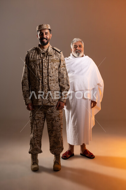 مشاركة اجواء رائعة لرجال الامن مع كبار السن، بورتريه لرجل عربي خليجي سعودي يرتدي الزي العسكري يقف بجوار رجل كبير بالسن يرتدي ثوب الاحرام، تأديه مناسك الحج والعمره بيسر وطمأنينه، الدردشه وتبادل الاحاديث مع الحجاج والمعتمرين، خلفيه برتقاليه