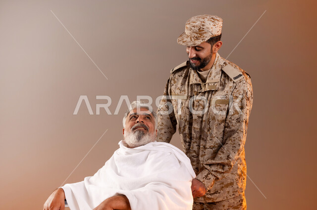 Helping pilgrims and Umrah pilgrims coming to Mecca to perform religious rituals, the gallantry of security personnel serving the guests of God, a portrait of a Saudi Gulf Arab man wearing a military uniform pulling a wheelchair for an elderly man wearing Ihram clothes with special needs, orange background.