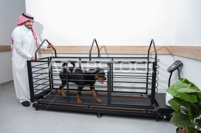 الشعور بالسعادة اثناء قضاء وقت ممتع في اللعب مع الحيوانات،  رجل يرتدي الزي التقليدي يقف بجانب الحيوان، المرح واللعب مع الحيوانات الأليفة ، اقتناء وتربية الكلاب ، حيوان ثديي أليف ، مفهوم الرفق بالحيوان