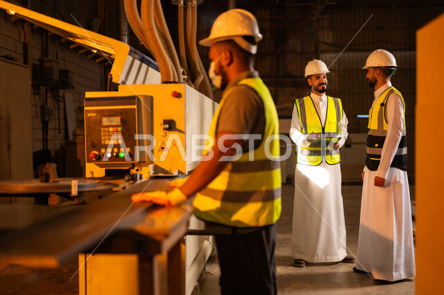 آلة النقش بالليزر, الطباعةعلى القطع الخشبية، التطور والتقدم التقني في صناعة الخشب، العمل في القطاع الصناعي, مهندسين عربيين خليجيين سعوديين يرتديان الخوذة وسترة الحماية يعملان في ورشة نجارة، معمل تصنيع الأثاث المنزلي