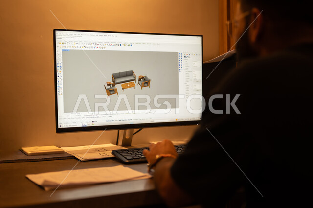 دمج التكنولوجيا بالعمل، استخدام الاجهزة التقنية الحديثة، تصوير مقرب لمصمم عربي خليجي سعودي يعمل على تصميم اريكة مريح باستعمال الحاسوب، مهن ووظائف هندسية مكتبية، نماذج ثلاثية الابعاد، مفهوم التخطيط والتنفيذ