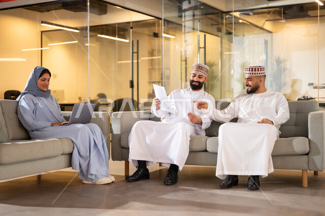 شرح استراتيجية وسياسة الشركة، فريق عمل عربي خليجي عماني يجلسون داخل مكتب، مفهوم تدريب وتطوير الموظفين, بيئة مريحة في الشركات العمانية، استخدام الأجهزة التقنية الحديثة في إنجاز المهام، مهن ووظائف إدارية في سلطنة عمان، تبادل الأحاديث ووجهات النظر بين الزملاء