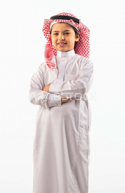 خلفية بيضاء لصبي صغير سعودي خليجي مبتسم وجميل ، ينظر الى الكاميرا بإيدي متقاطعة بإيماءات وجه ويدين مختلفة , بورتريه لطفل سعودي خليجي سعيد يرتدي الزي السعودي التقليدي مع شماغ وعقال , الاحتفال بعيد الفطر السعيد ،عيد الفطر المبارك