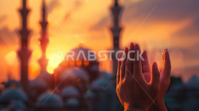 العباده والتقرب الى الله، صورة مقربة لأيدي امرأة مسلمة عربية خليجية سعودية ترفع يديها للدعاء، التضرع و طلب العون والحمد والشكر، خلفية المسجد