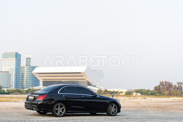 سيارة مركونة على الشارع العام، وسائل النقل في الامارات العربية المتحدة، المعالم الثقافية المشهورة, مكتبة محمد بن راشد بمدينة دبي في الخلفية, الفن الهندسي في تصميم شكل الكتاب المفتوح للمكتبة