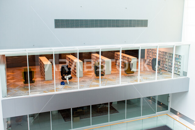 تأمين وسائل الراحة للقراء، مكان للقراء ومحبي العلم والمعرفة، اكتساب المعرفة وتنمية الذخيرة اللغوية، شاب عربي إماراتي خليجي يجلس على كرسي في مكتبة محمد بن راشد الثرية بالمجلات والمعاجم في امارة دبي، المكتبات العلمية في الامارات العربية المتحدة