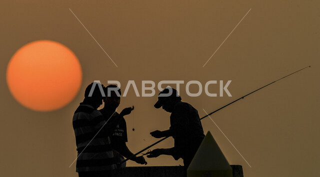 وافدون يمارسون هواية صيد السمك أثناء غروب الشمس فى الكويت ، هواية الصيد ، انشطة ترفيهية
