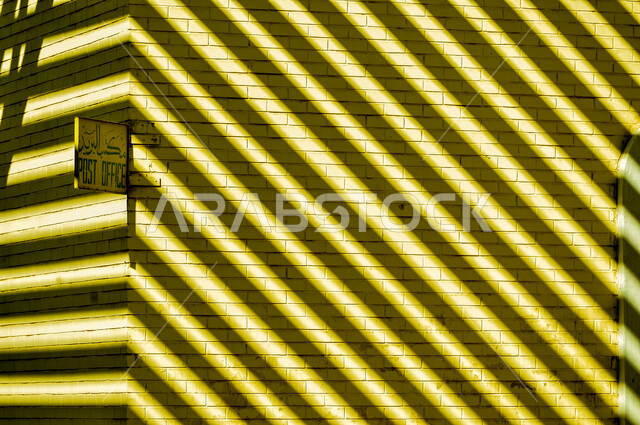 Sun shadows on the wall of the post office in an old popular market in Kuwait City