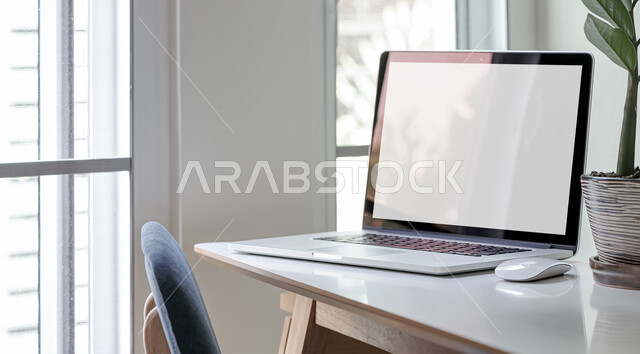 The concept of utilizing free time to develop mental skills, using advanced technologies, a close-up image of a laptop on a wooden table, displaying a blank white screen on a laptop, the role of modern technology in providing greater comfort for individuals
