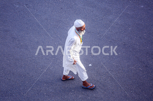 الركن الخامس من أركان الإسلام، زيارة بيت الله الحرام في مكة المكرمة , العبادة والتقرب إلى الله , صورة من الأعلى لرجل يرتدي ملابس الاحرام يقوم بأداء مناسك الحج و العمرة 
