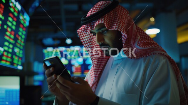 استخدام الأجهزة التقنية والتكنولوجية الحديثة، التواصل والدردشة مع الأصدقاء والأقارب عبر الجوال، صورة مقربة لرجل عربي خليجي سعودي يرتدي الزي التقليدي يمسك بيده الهاتف المحمول، قضاء أوقات ممتعة، تصفح مواقع التواصل الاجتماعي