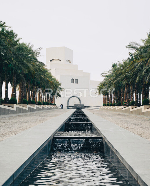 الفن الهندسي المعماري المتطور للمباني , ممر مائي في الفناء الخارجي لمتحف الفن الإسلامي في مدينة الدوحة ، المعالم الثقافية المشهورة في دولة قطر ، الاهتمام بزراعة الأشجار والنباتات الخضراء والمناظر العامة في المناطق السياحية
