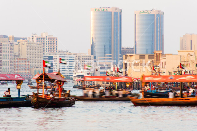 سفينة لأخذ السياح جولة في مياه الخليج, التعرف على معالم المدينة واستكشافها, القوارب الخشبية في المرفأ في منطقة بر دبي بالإمارات العربية المتحدة، الواجهة البحرية السياحية في المدينة القديمة، وسائل النقل عبر البحر, النمو والتطور العمراني للأبراج وناطحات السحاب