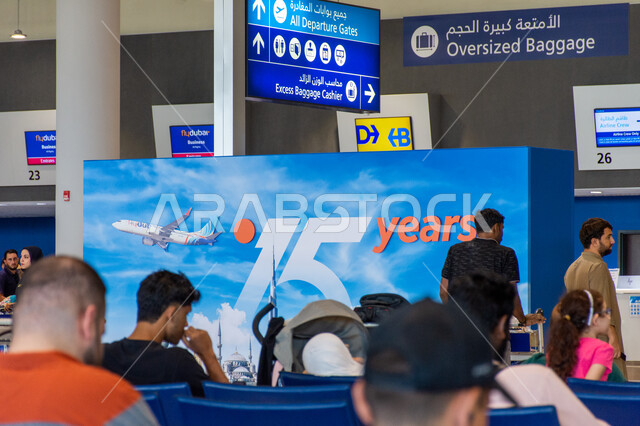 مسافرون يجلسون في صالات الانتظار، الديكورات الداخليه والفن الهندسي المتميز لمطار دبي الدولي، شاشات الكترونية ارشادية، السياحة والسفر في الإمارات العربية المتحدة، اهم مركز جوي في الشرق الاوسط