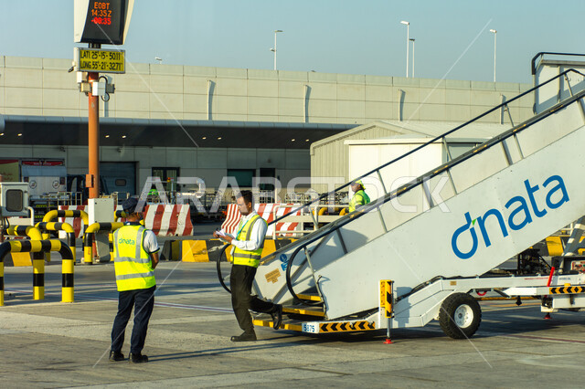 Maintenance and cargo workers in Terminal 02 runway at Dubai International Airport, tourism in the United Arab Emirates, Emirati airlines and companies, landing and take-off runways, means of transportation and air transportation, providing advanced services for easy movement between countries, the most important air center in the Middle East.