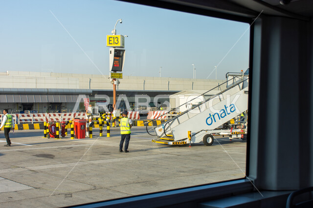 Maintenance and cargo workers in Terminal 02 runway at Dubai International Airport, tourism in the United Arab Emirates, Emirati airlines and companies, landing and take-off runways, means of transportation and air transportation, providing advanced services for easy movement between countries, the most important air center in the Middle East.