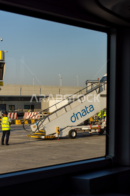 عمال الصيانة والشحن في مدرج مبنى 02 في مطار دبي الدولي، السياحة في إلإمارات العربية المتحدة، شركات وخطوط الطيران الاماراتية، مدرج الهبوط والإقلاع، وسائل النقل والمواصلات الجوية، توفير الخدمات المتطورة لسهولة التنقل بين البلدان، اهم مركز جوي في الشرق الاوسط