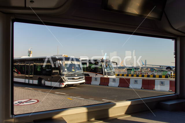 Buses to transport passengers to the plane in Terminal 02 runway at Dubai International Airport, the concept of tourism in the United Arab Emirates, Emirati airlines and companies, landing and take-off runway, means of transportation and air transportation, providing advanced services for easy movement between countries.